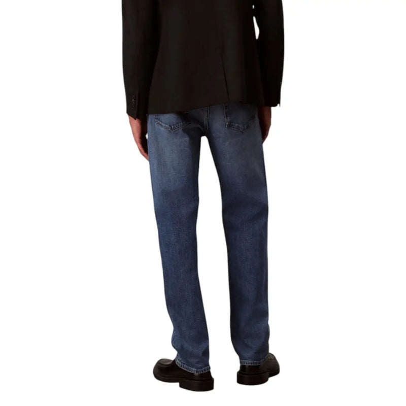 Men’s blue jeans in medium-wash denim with classic straight-leg cut visible stitching and standard back pockets shown from back