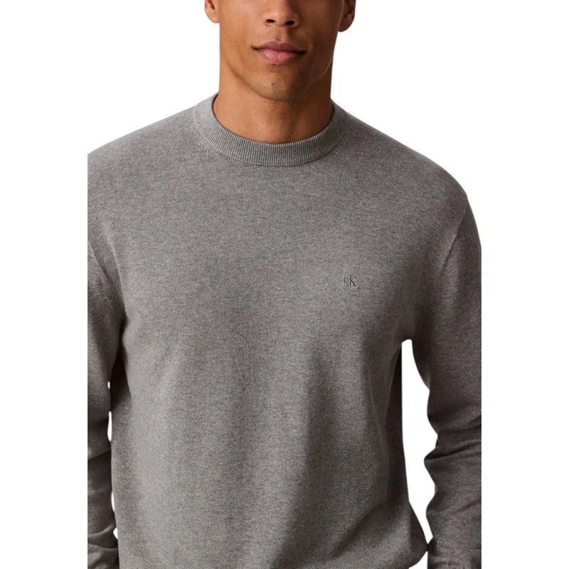 Mens gray long sleeved sweater made of heathered fabric with a crewneck and subtle embroidered logo on the left chest