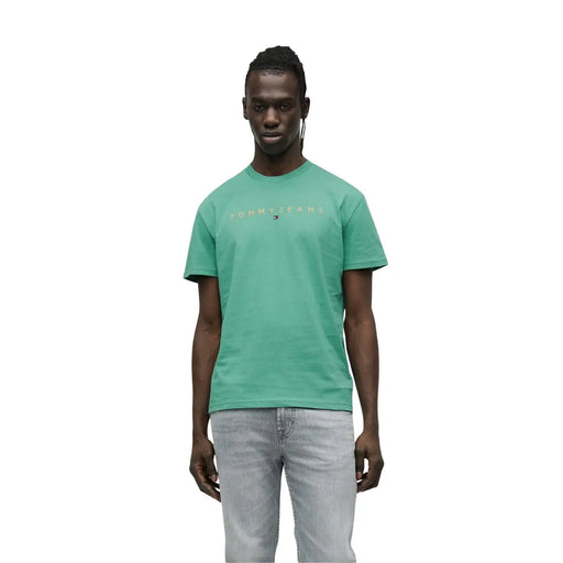 Mens white tommy jeans short sleeve t shirt featuring a teal color with a subtle gold logo across the chest