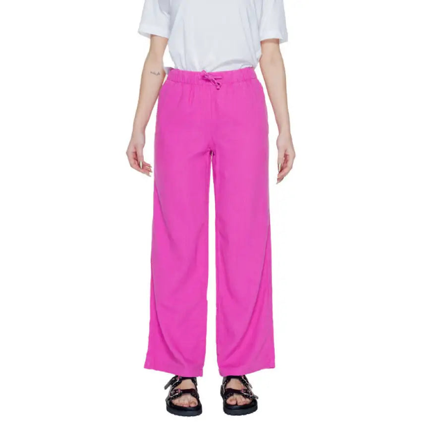 Model in urban style clothing, white t-shirt and pink Only Women Trousers in city