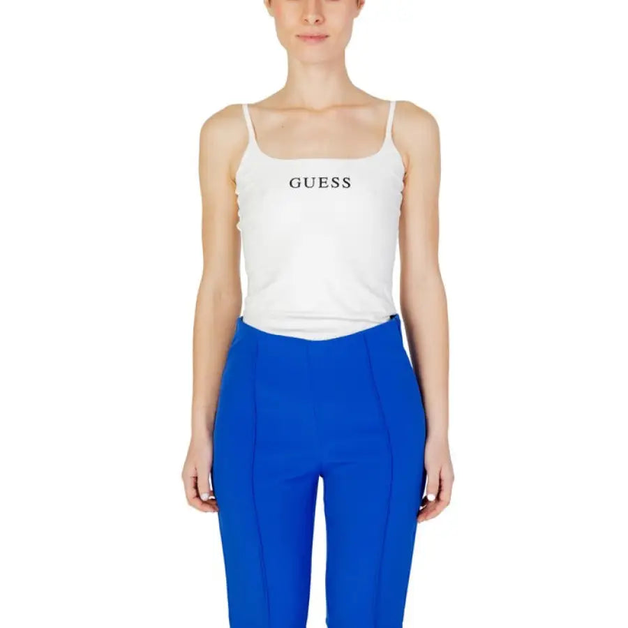 Model in Guess Active white tank top and blue pants for active lifestyle