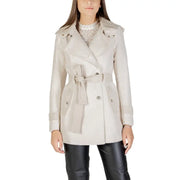 Beige double-breasted trench coat with belt and wide lapels over white lace top and black pants
