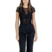 Women wearing a black lace short-sleeve bodysuit paired with high-waisted dress pants