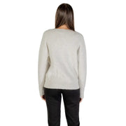 Light grey long-sleeved V neck knit sweater paired with black trousers for women