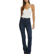 Dunkelblaue, hochgeschnittene Jeans aus Denim mit ausgestelltem Bein und Ziernähten am Bund, kombiniert mit einem weißen Tanktop aus Viskose-Elastan. top