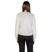 Woman wearing a light grey patterned knit sweater and black pants, showcasing Morgan De Toi cardigan