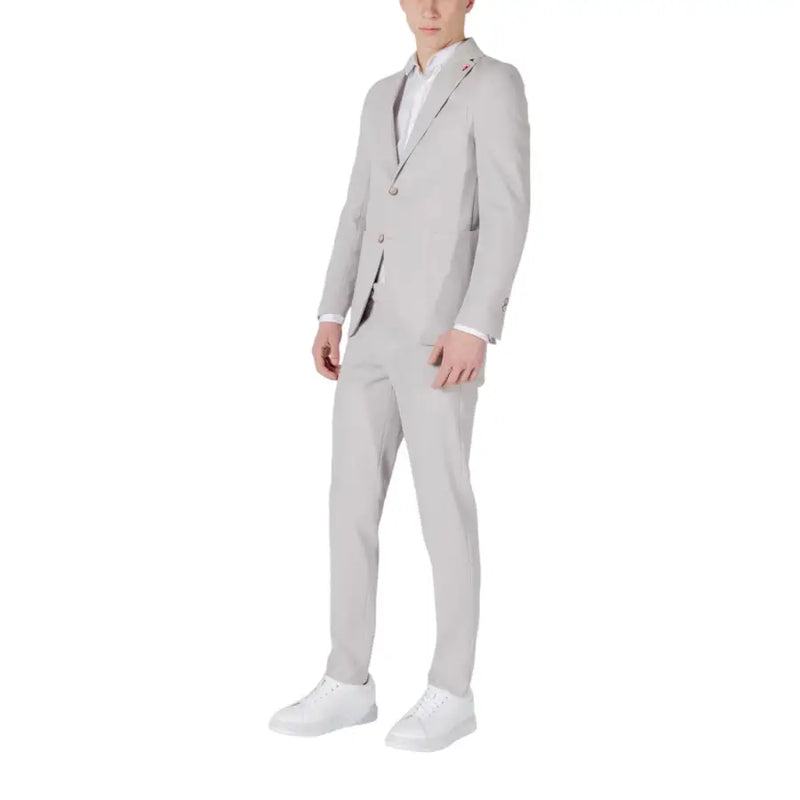 Men’s light grey two-piece suit with white dress shirt and sneakers for spring summer style