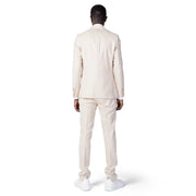 A man wearing a cream-colored Mulish men suit made of beige polyester viscose blend with matching trousers and white sneakers