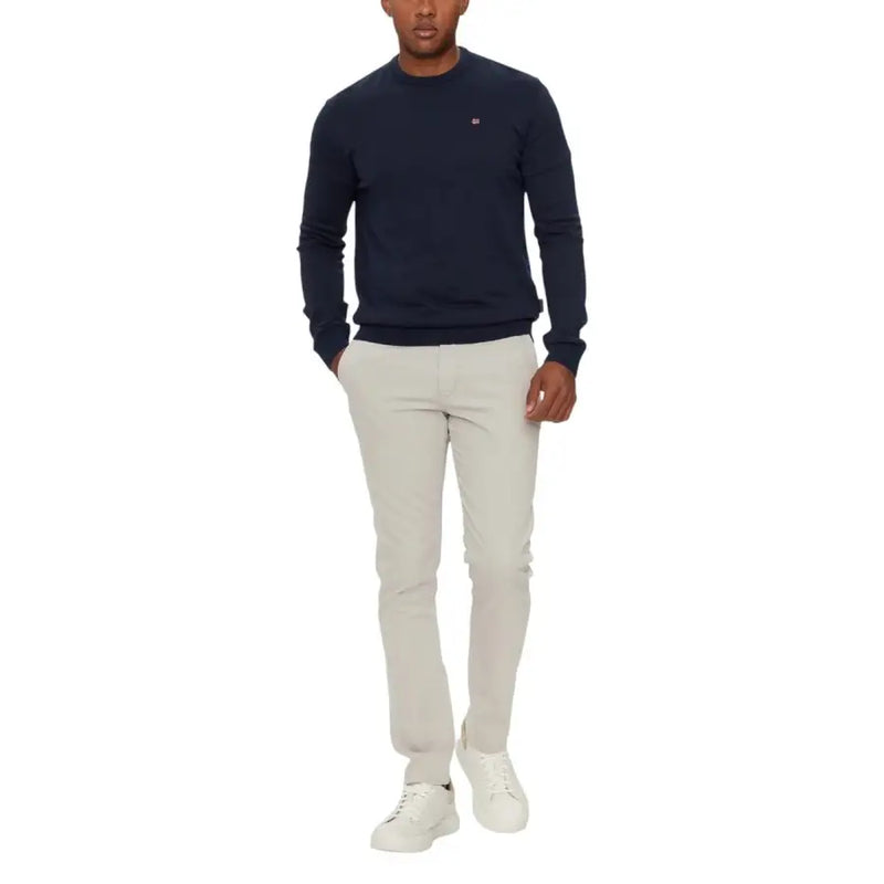 Navy blue crew neck sweater with white logo and light gray pants