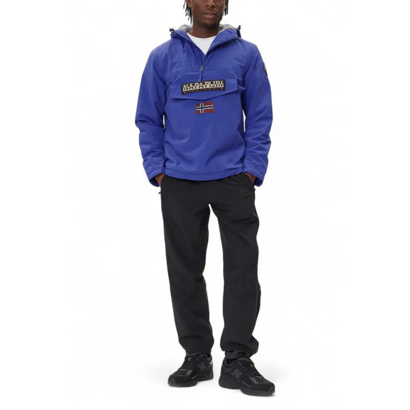 Royal blue anorak jacket with hood and logo patch, likely made of nylon or polyester material.