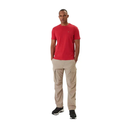 Beige Cargohosen mit mehreren Seitentaschen und dezenten napapijri Logo auf dem linken Oberschenkel, kombiniert mit einem roten Baumwoll-T-Shirt