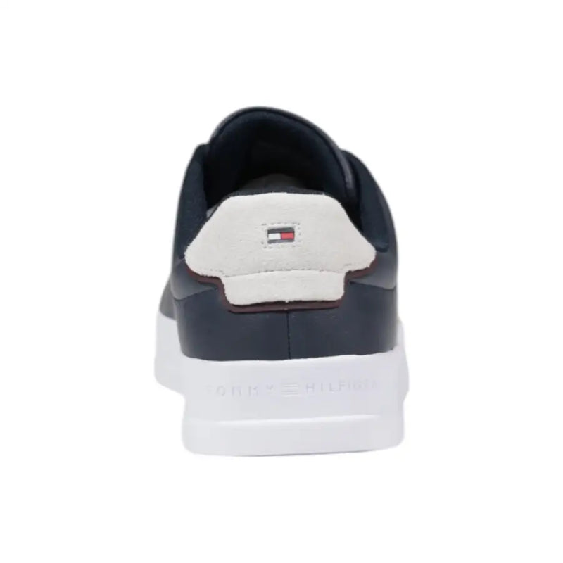 Navy blue leather sneaker with white sole and suede heel tab featuring tommy hilfiger logo shown from back side