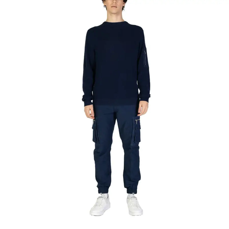 Navy blue long sleeved knit sweater featuring a subtle zippered pocket on the left sleeve for practical use