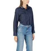 Navy long-sleeve collared shirt with rhinestone embellishments paired with distressed wide-leg jeans