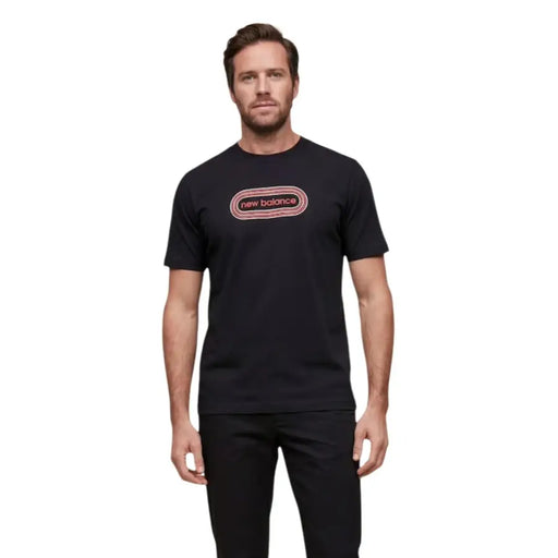 New Balance men t-shirt in black featuring a pink and white oval logo with the brand name centered on the chest