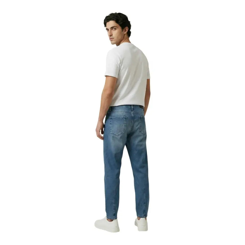 New balance Männer t-shirt kombiniert mit blauen Jeans im klassischen Fünf-Taschen-Design und dezenter Waschung
