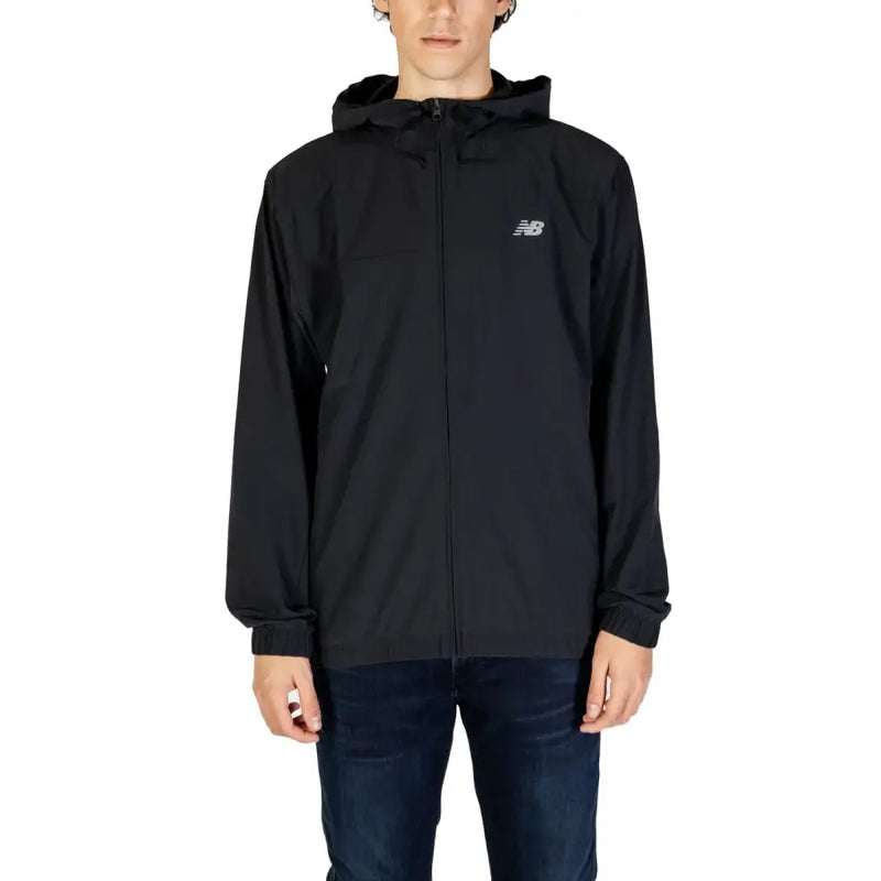 Men’s black hooded windbreaker jacket with full-zip front and elastic cuffs paired with dark blue jeans
