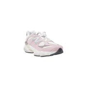 New balance women leather sneakers in pink with white and gray accents showing the side view