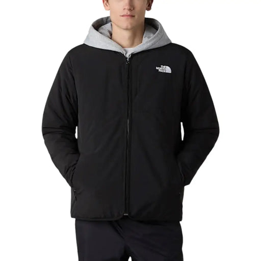 Der schwarze, lange Nylonblazer von The North Face für Herren mit Reißverschluss verfügt über eine schwarze Kapuze mit grauem Innenfutter und ein Logo auf der Brust.
