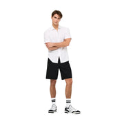 Only Schwarze Jeansshorts für Herren, getragen von einem Model (Vorderansicht), kombiniert mit einem weißen Kurzarmhemd und Sneakers.