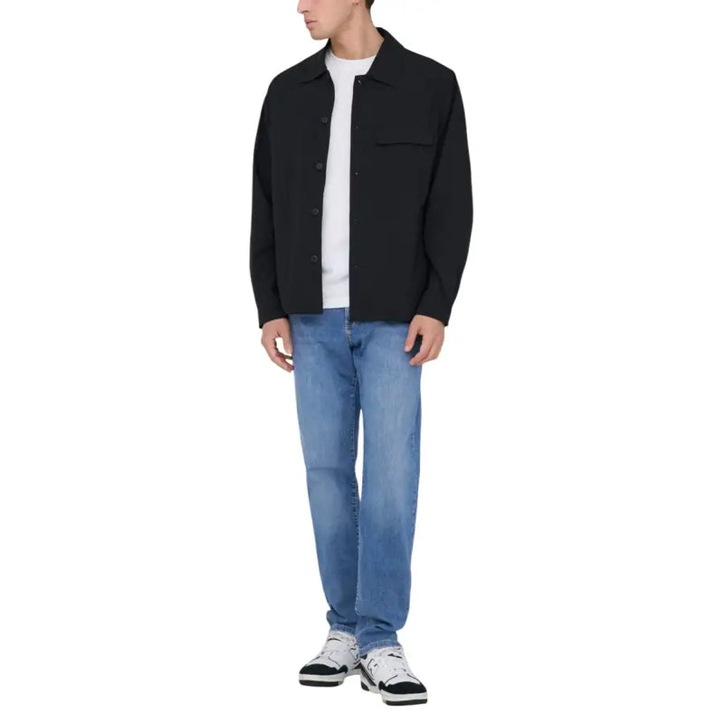 Schwarze, geknöpfte Jacke mit klassischem Kragen und Brusttasche, getragen über einem weißen T-Shirt, kombiniert mit only und Söhne Herren hellblaue Baumwolljeans