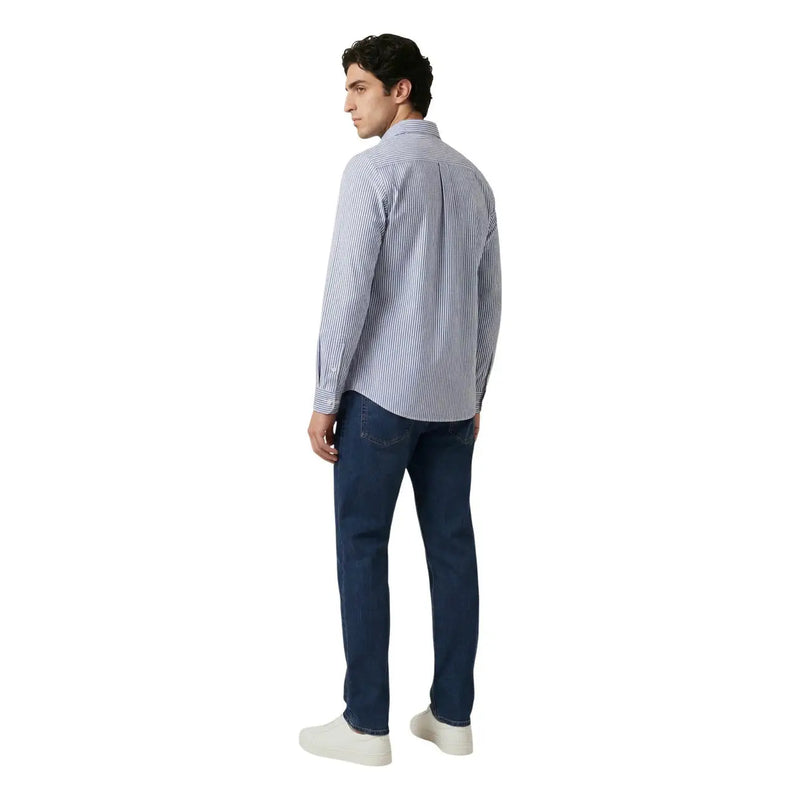 A man wearing an Only & Sons men shirt featuring light blue and white vertical stripes with dark wash denim jeans