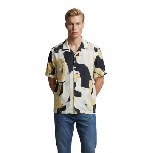 A man wearing an Only & Sons men shirt with a black and yellow abstract pattern on a cream short-sleeved fabric