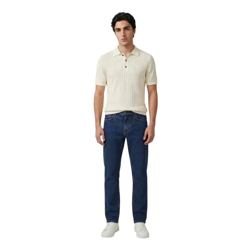 A man wearing an Only and Sons men white cotton polo short sleeve shirt in cream ribbed knit with dark blue jeans