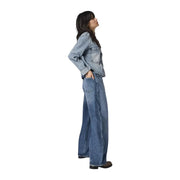 Eine Frau, die only Damen-Jeans im Barrel-Stil aus Baumwoll-Denim mit hellblauer Jeansjacke und hochgekrempelten Ärmeln.