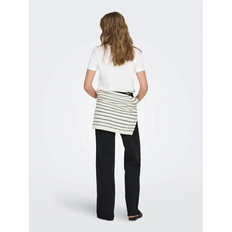 A white round neck cotton short t shirt paired with a white and black striped ribbed knit wrap skirt over dark trousers