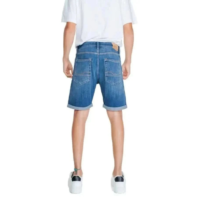 Jack & Jones Männer Shorts: Blaue Jeansshorts mit hochgekrempelten Hosenbeinen, getragen von einer Person