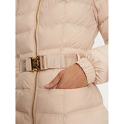 Close-up of a person wearing a belted light pink puffer jacket with gold buckle and ribbed cuffs