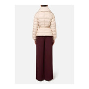 Women wearing a belted cream puffer jacket with wide-leg burgundy trousers by Elisabetta Franchi