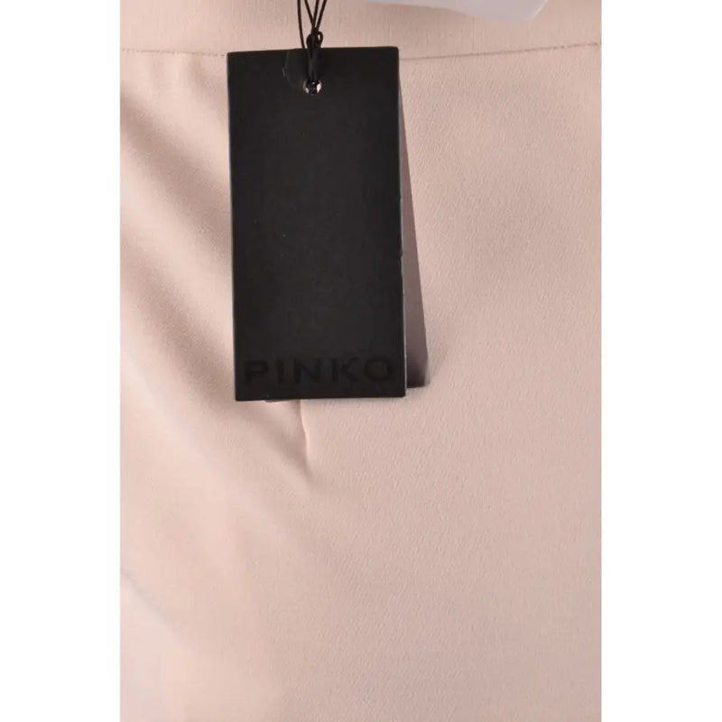 Black rectangular tag with pinko embossed on a beige plain zip skirt for women fall winter collection