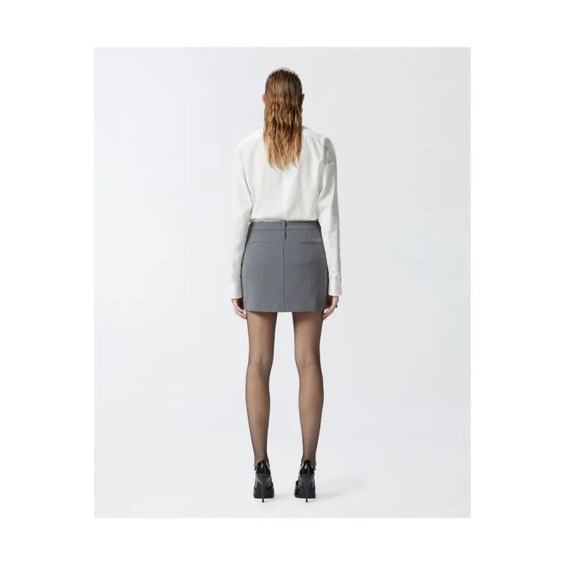 Pinko grey tailored mini skirt with structured waistband and front pockets worn with white blouse and black heels