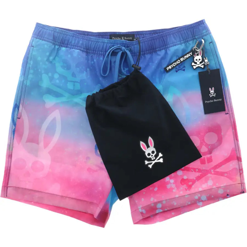 Psycho Bunny Herren-Badehose aus leichtem Polyester mit blau-rosa Farbverlauf und Totenkopf-Hasenmotiven.