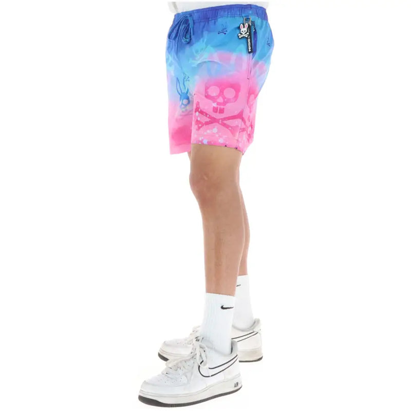 Psycho Bunny Herren-Badehose aus pinkfarbenem Polyester mit leuchtenden Farbverläufen, auffälligen Totenkopf- und weißen Hasenmotiven.