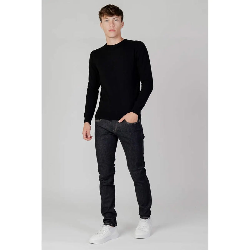 Black long-sleeved crewneck sweater made of soft knit fabric paired with Replay men blue slim fit jeans with zip and button M914Y