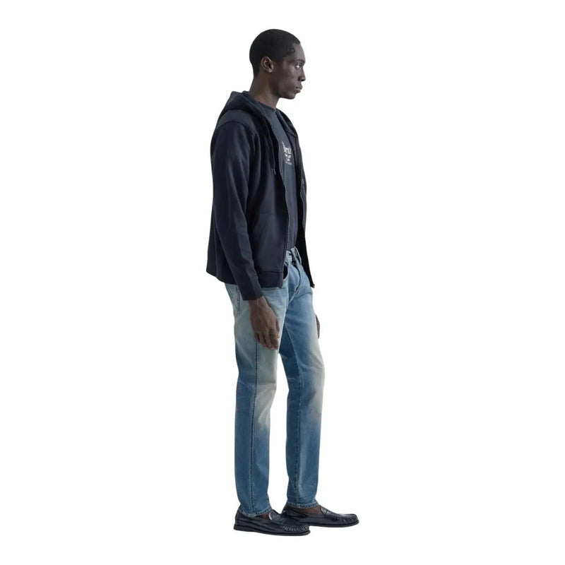 Replay Slim-Fit-Jeans von Anbass für Herren aus hellblauem Denim, getragen vom Model mit marineblauem Kapuzenpullover mit Reißverschluss, Vorderansicht