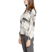 A woman wearing a Rinascimento grey print long sleeve viscose blouse with sheer fabric and abstract black and white pattern