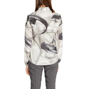 A woman wearing a rinascimento grey print long sleeve viscose blouse with black abstract brushstroke patterns