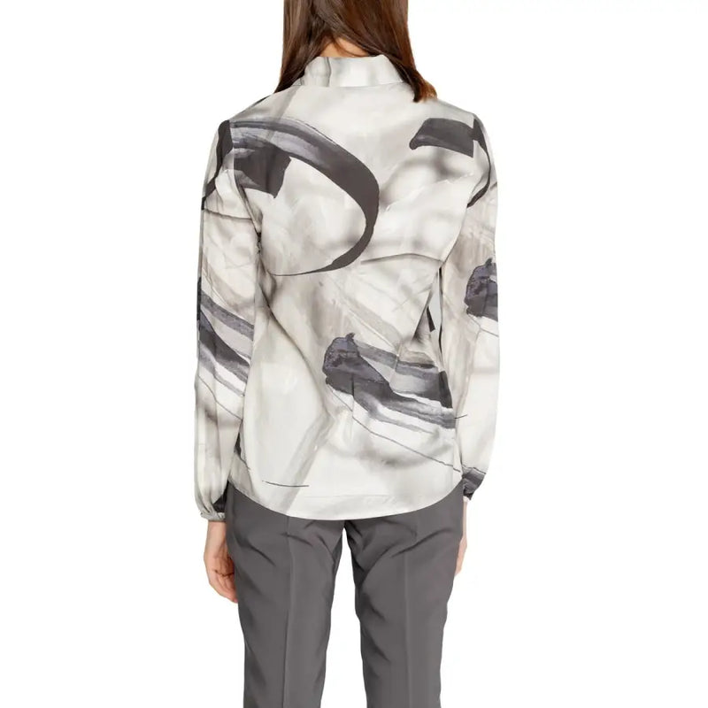 A woman wearing a rinascimento grey print long sleeve viscose blouse with black abstract brushstroke patterns