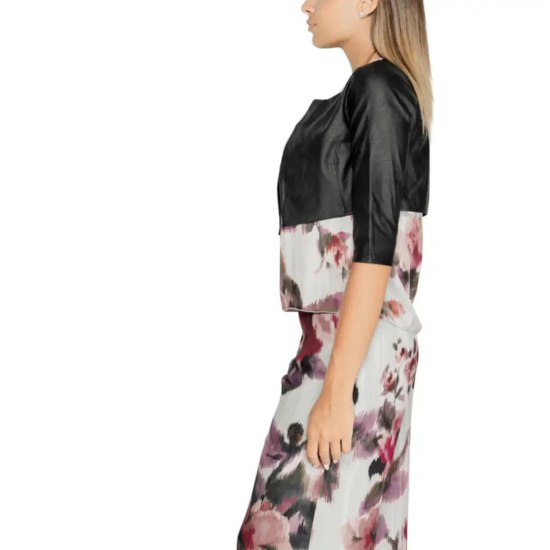 Rinascimento women black polyurethane blazer with three quarter sleeves paired with floral pastel skirt shown from front