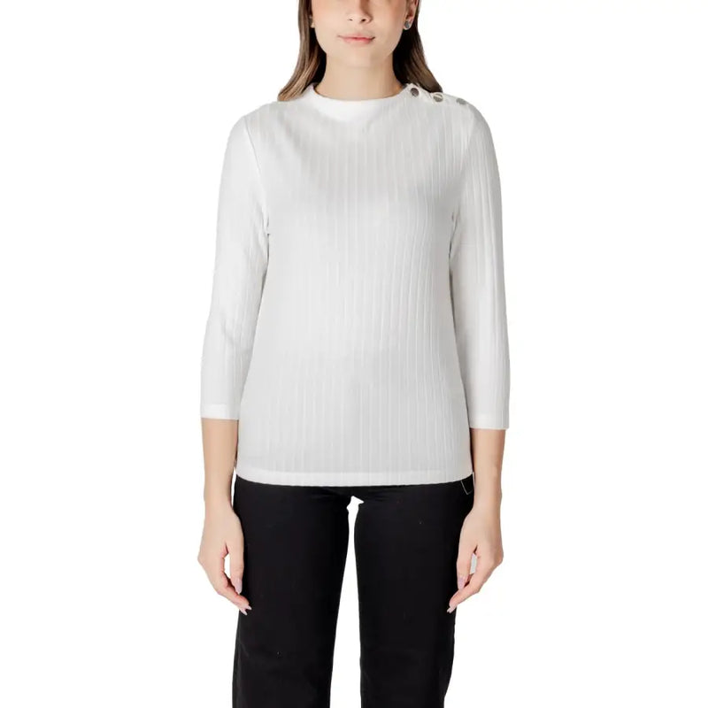 Woman wearing a white ribbed knit top with decorative shoulder buttons from Street One