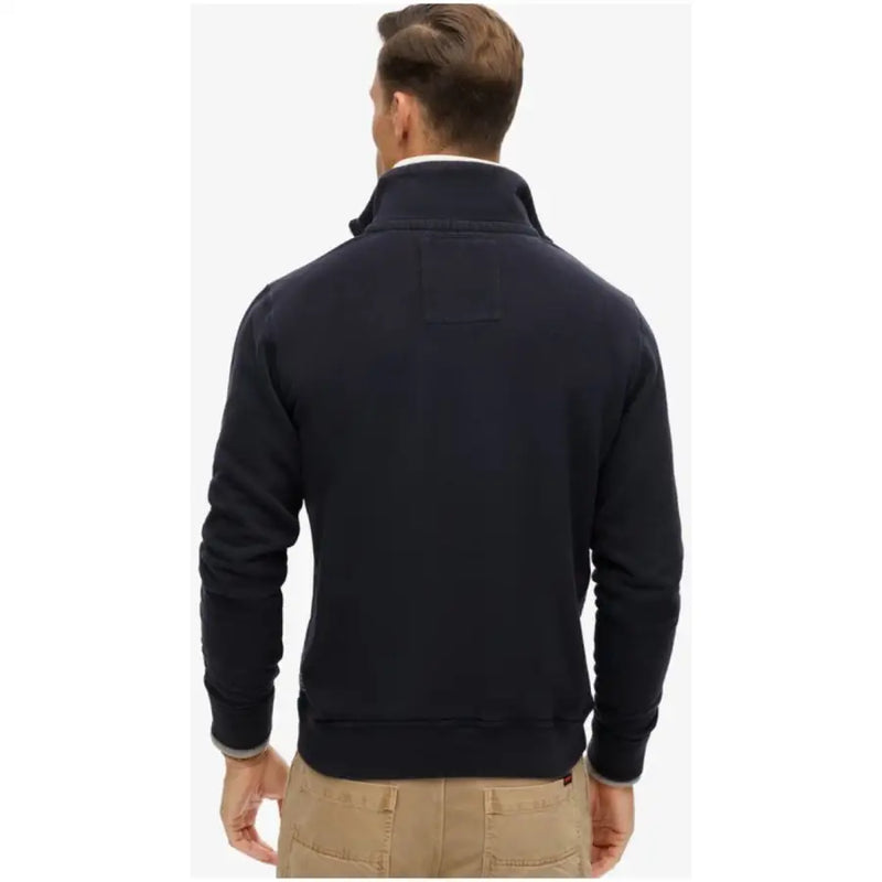 Men’s navy blue full-zip cotton sweatshirt with high collar paired with tan pants