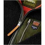 Black Superdry Mountain fleece jacket with olive green accents, orange lining, zippers, and outdoor patches