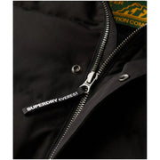 Schwarzer Superdry Everest Steppjacken-Reißverschlussanhänger mit weißer Schrift an Kapuzen-Winterjacke für Herren M5011743A