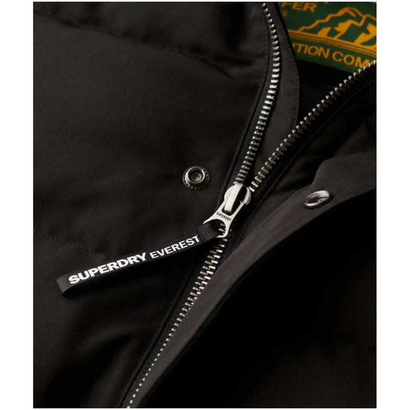 Schwarzer Superdry Everest Steppjacken-Reißverschlussanhänger mit weißer Schrift an Kapuzen-Winterjacke für Herren M5011743A