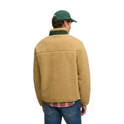 Hellbraune Shearling-Jacke mit dunkelgrünem Kragen und passender Mütze, kombiniert mit einem gelben Super-Dry Herren-Fleece-Sweatshirt mit durchgehendem Reißverschluss.