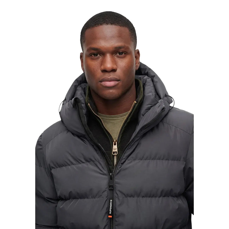 Superdry Steppjacke für Herren in Dunkelgrau mit Steppmuster und goldfarbenem Reißverschlussanhänger, Vorderansicht